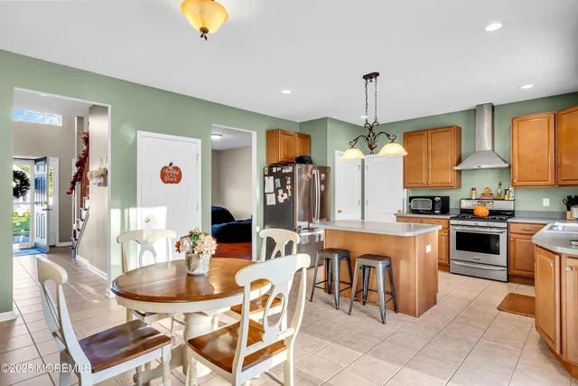 a kitchen with stainless steel appliances kitchen island granite countertop a table and chairs in it