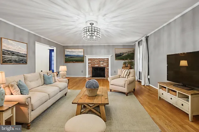 an empty room with wooden floor chandelier fan and windows