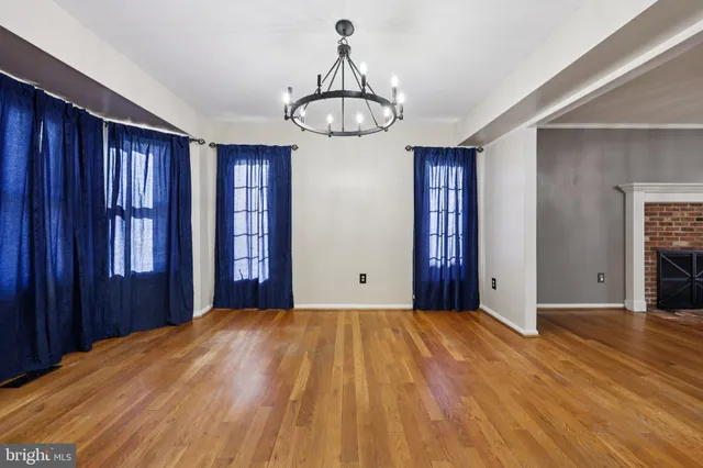 a view of an empty room with a window and kitchen view