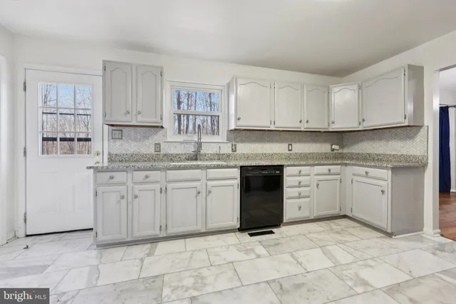 a view of a hallway with wooden floor and a bathroom