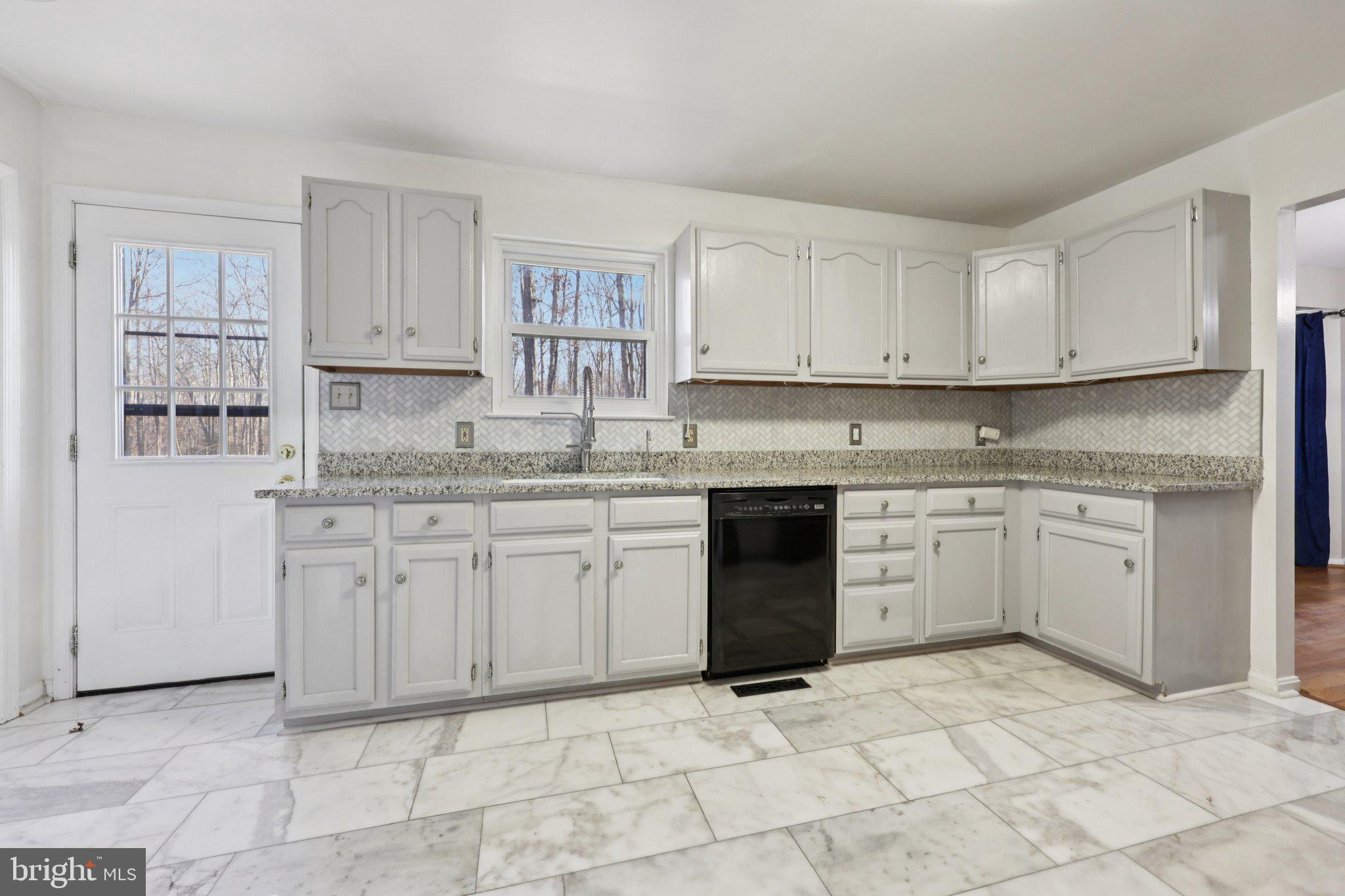 13445 Blackwells Mill Road Goldvein, VA 22720 - Photo 24 of 95 a kitchen with stainless steel appliances granite countertop a stove a sink and white cabinets