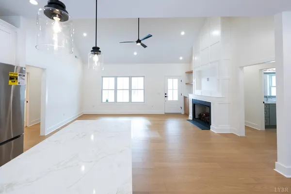 a view of an empty room with a window and a kitchen