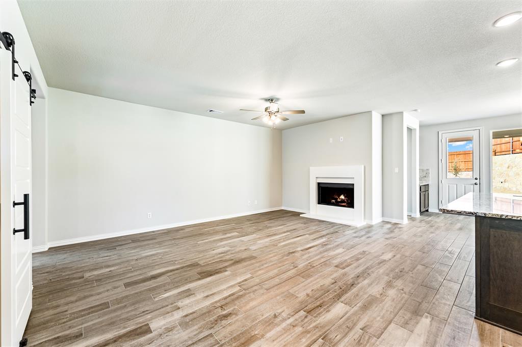 541 Mitchell Boulevard Weatherford, TX 76087 - Photo 3 of 30 a view of empty room with wooden floor and fireplace