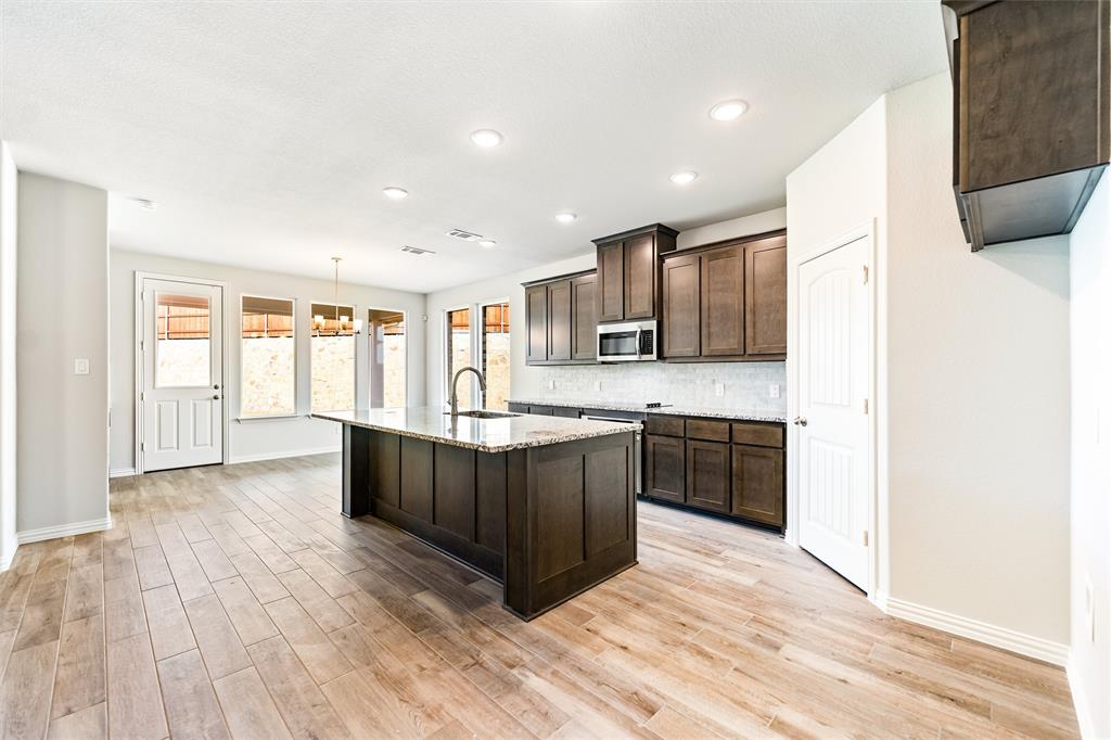 541 Mitchell Boulevard Weatherford, TX 76087 - Photo 5 of 30 a large kitchen with stainless steel appliances granite countertop a large counter top and wooden floors