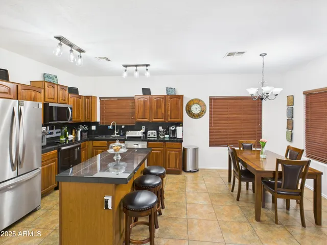 a kitchen with stainless steel appliances granite countertop a sink a stove and a refrigerator