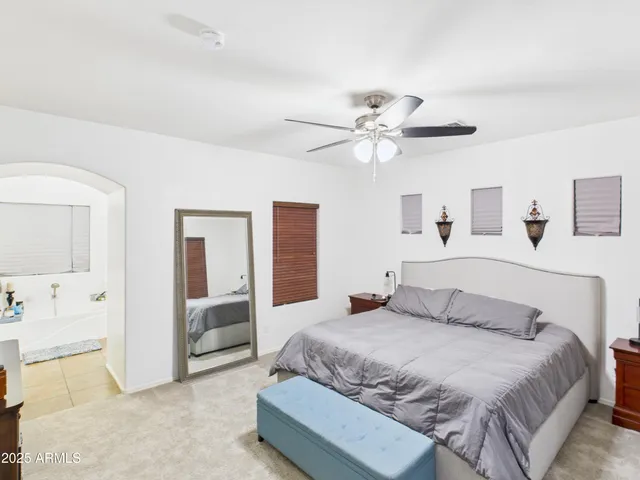 a bedroom with a large bed and a chandelier