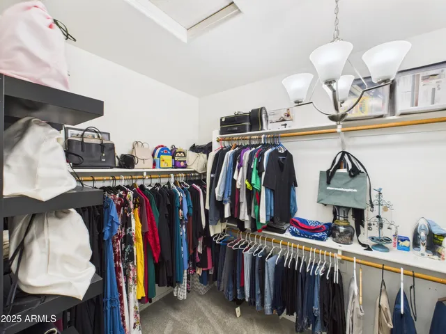 a view of walk in closet with clothes and shoes