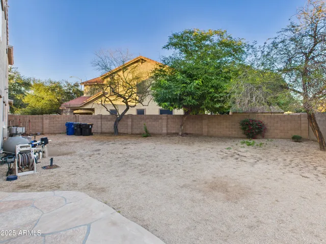 a backyard of a house with table and chairs