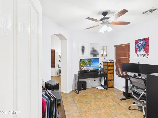 a workspace with furniture and ceiling fan
