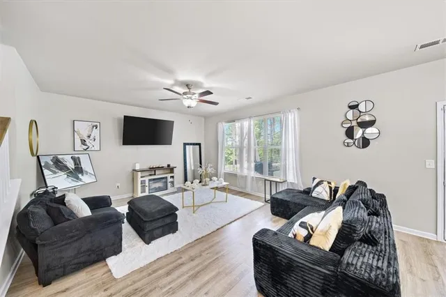a living room with furniture kitchen view and a chandelier
