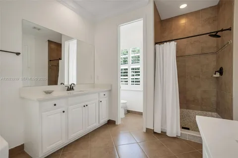 a bathroom with a double vanity sink a toilet and shower