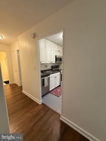a kitchen with stainless steel appliances a refrigerator and wooden floor