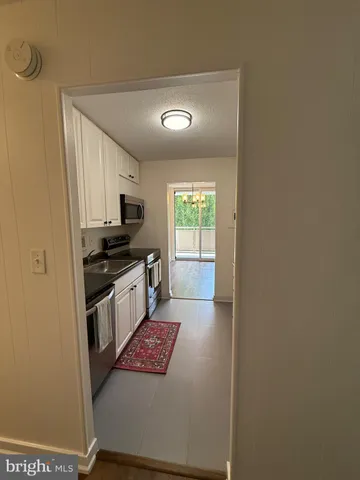a kitchen with a refrigerator and a stove top oven