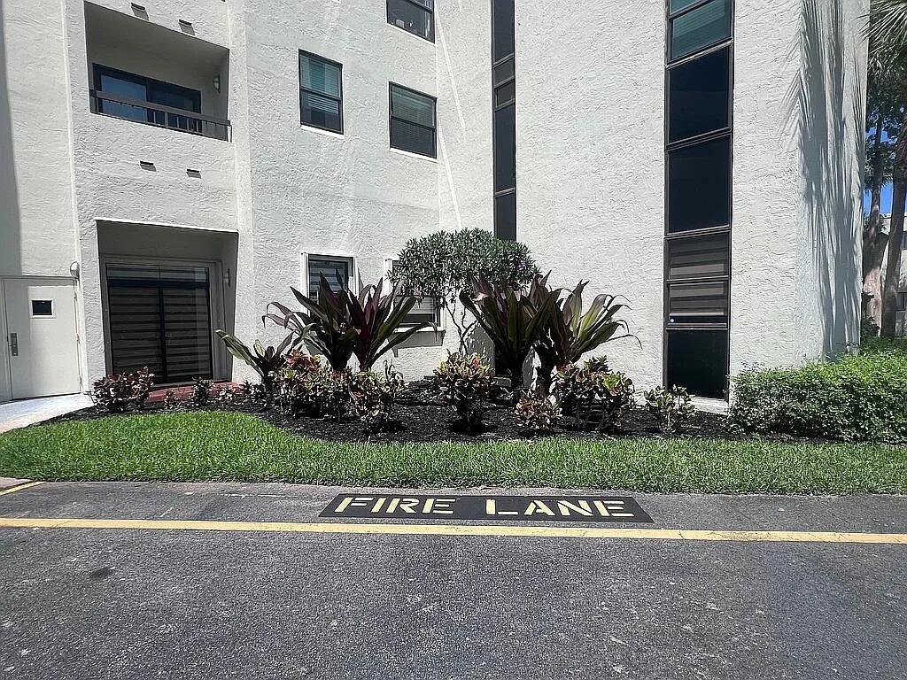 6463 La Costa Drive, Unit 105 Boca Raton, FL 33433 - Photo 34 of 40 a front view of a house with a garden and yard