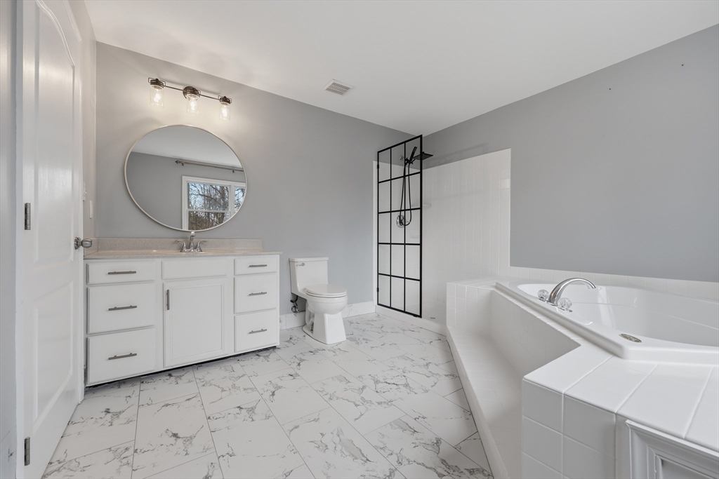 35 Peter Street Holliston, MA 01746 - Photo 26 of 42 a spacious bathroom with a toilet sink and mirror