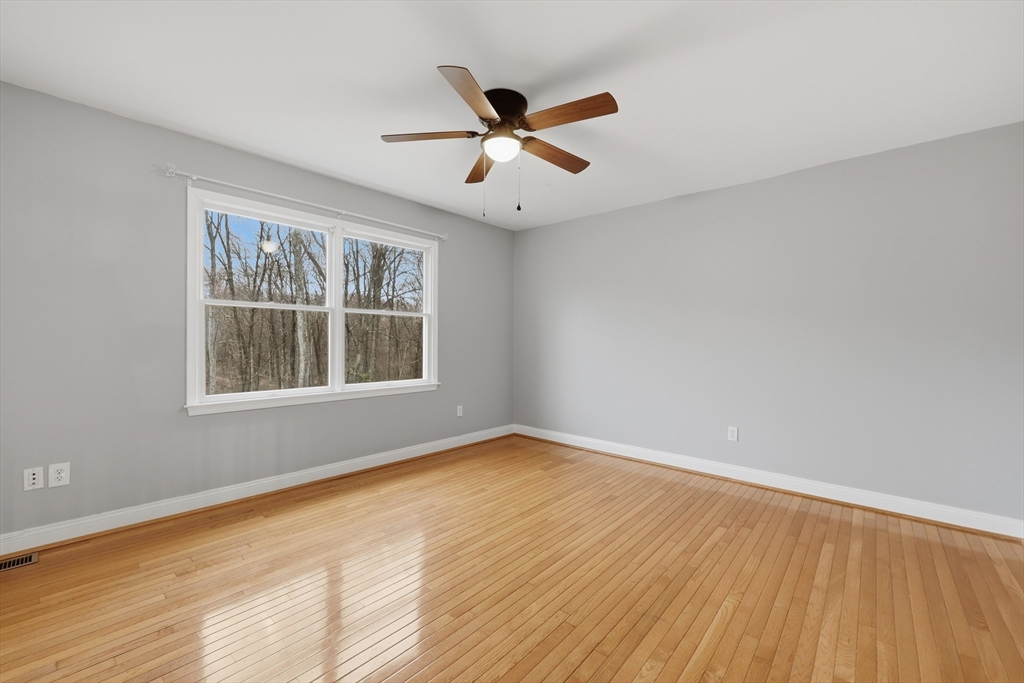 35 Peter Street Holliston, MA 01746 - Photo 30 of 42 an empty room with wooden floor ceiling fan and windows