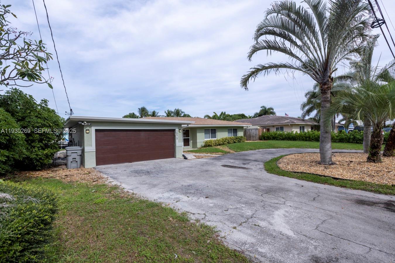2875 Northeast 19th Street Pompano Beach, FL 33062 - Photo 44 of 79 a front view of a house with a yard and garage