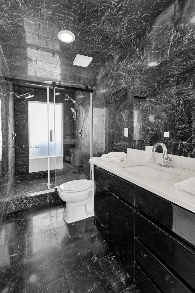 2875 Northeast 19th Street Pompano Beach, FL 33062 - Photo 61 of 79 a bathroom with a sink a toilet and shower