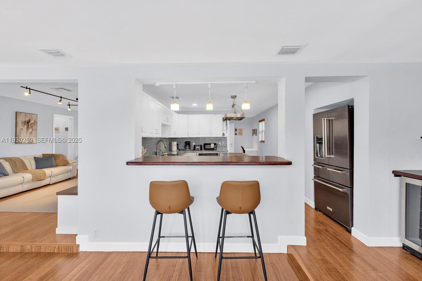 2875 Northeast 19th Street Pompano Beach, FL 33062 - Photo 65 of 79 a kitchen with stainless steel appliances granite countertop a refrigerator a stove a sink dishwasher and a dining table with wooden floor