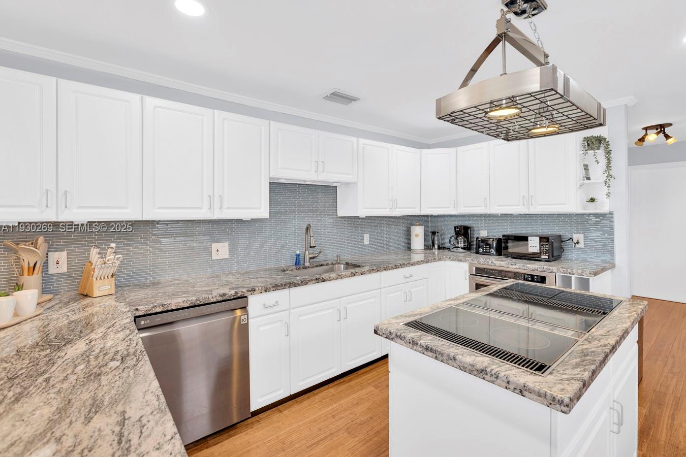 2875 Northeast 19th Street Pompano Beach, FL 33062 - Photo 66 of 79 a kitchen with stainless steel appliances granite countertop a sink stove and white cabinets