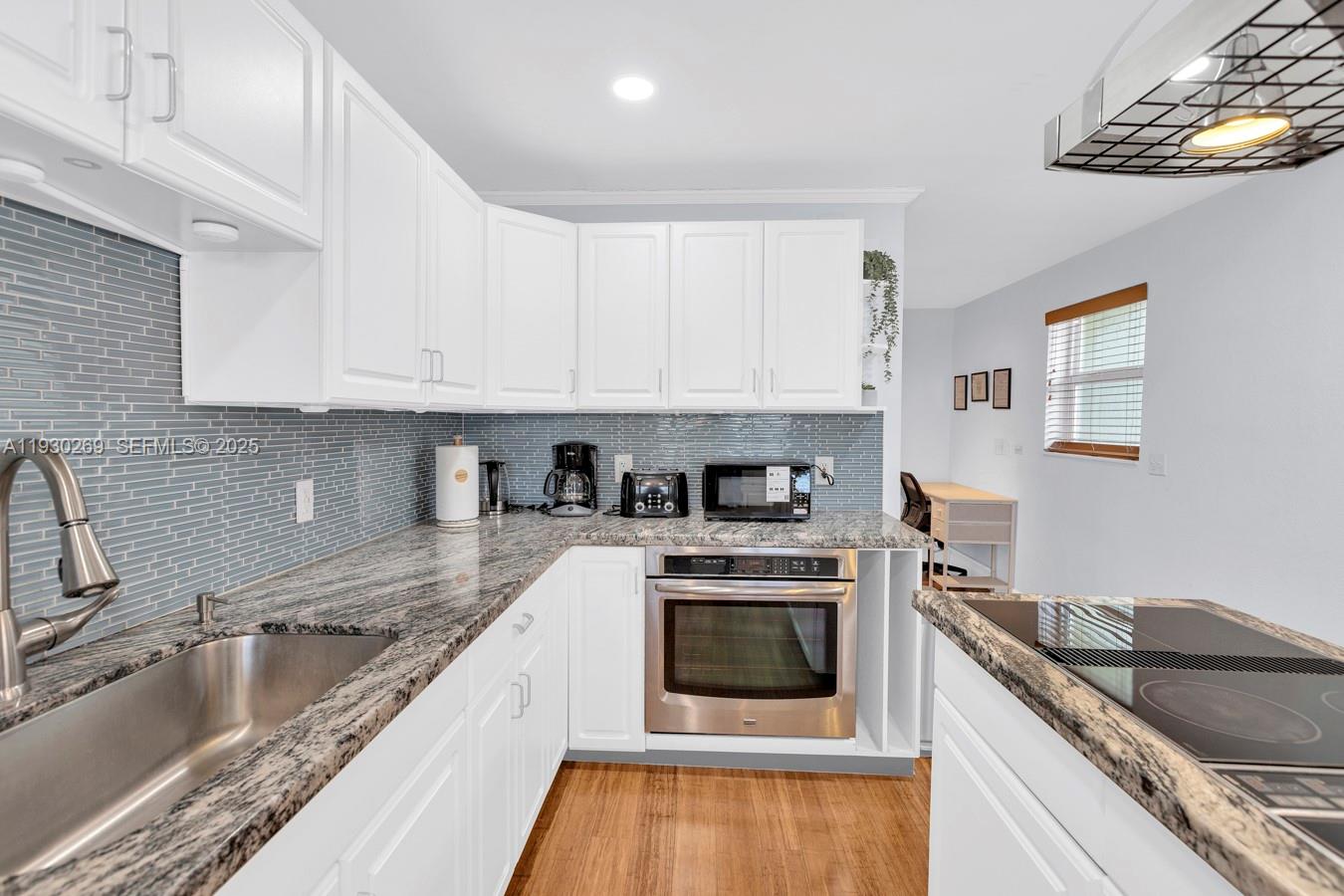 2875 Northeast 19th Street Pompano Beach, FL 33062 - Photo 67 of 79 a kitchen with granite countertop a stove sink and cabinets
