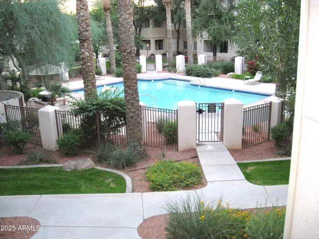 a view of a house with a yard and table and chairs under an umbrella