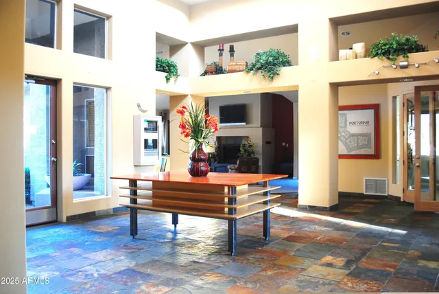 a living room with patio furniture and a potted plant