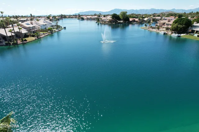an aerial view of water body with boats and trees all around
