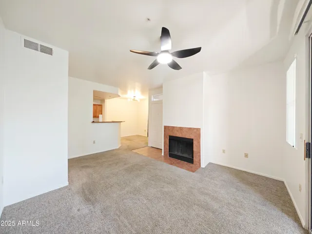 a view of empty room with a fireplace and window