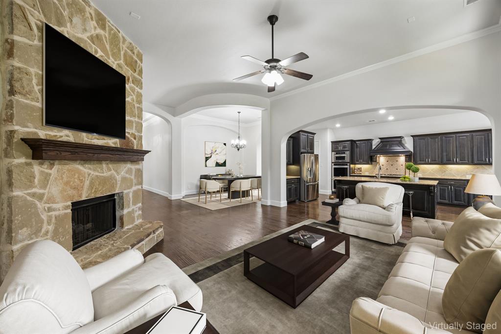 1567 Red Rock Canyon Road Frisco, TX 75036 - Photo 14 of 36 Virtually staged. Stone fireplace anchors the living-kitchen area.