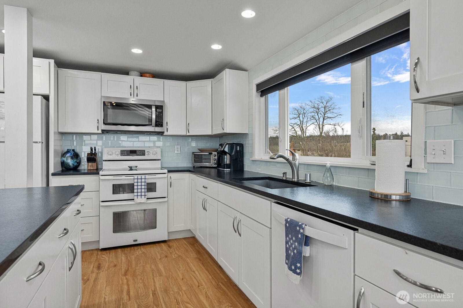 2508 Sunlight Beach Road Clinton, WA 98236 - Photo 11 of 33 a kitchen with stainless steel appliances white cabinets a sink and a stove