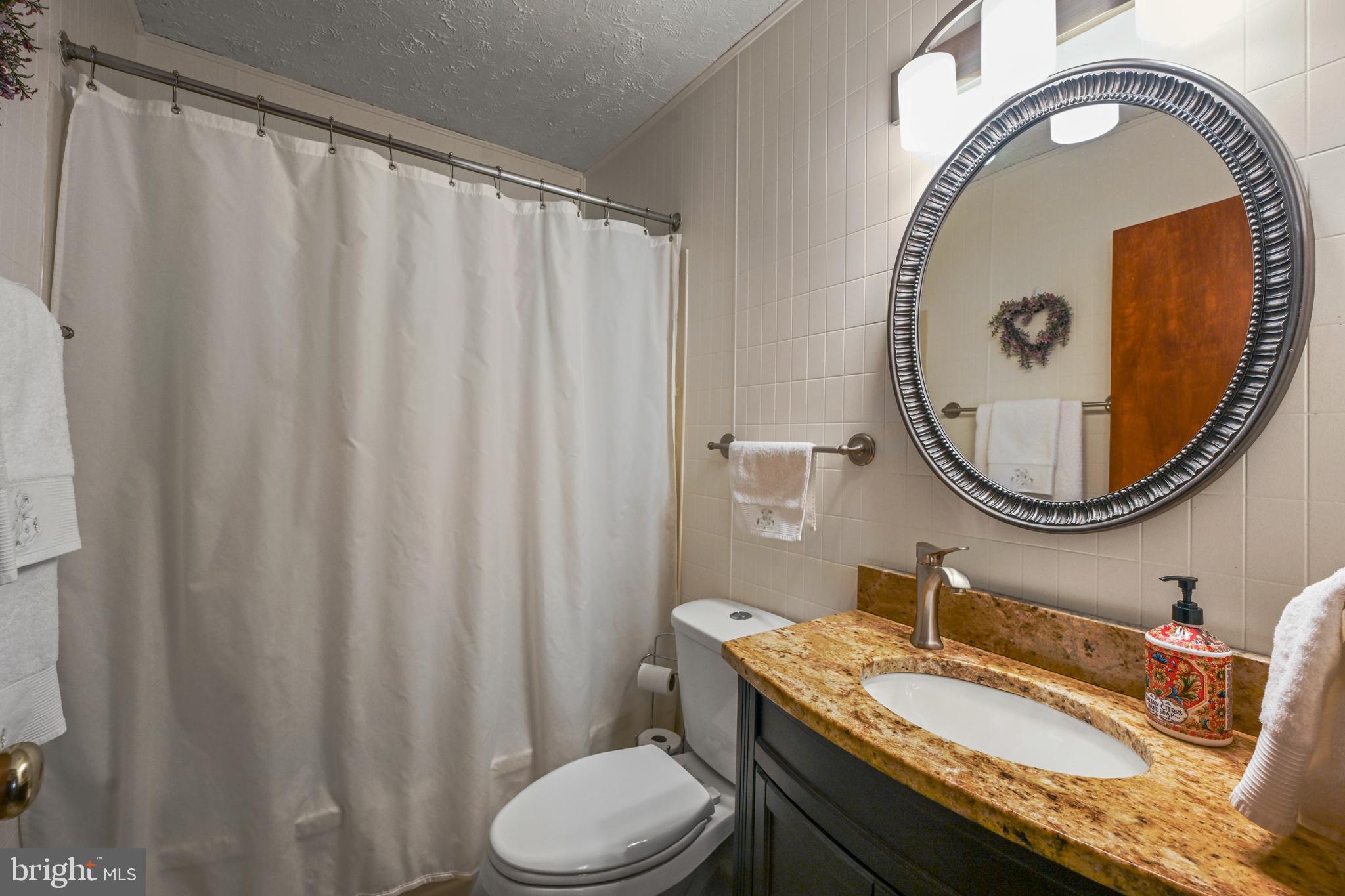 1027 Upton Road Glen Burnie, MD 21060 - Photo 10 of 39 a bathroom with a granite countertop sink and a mirror