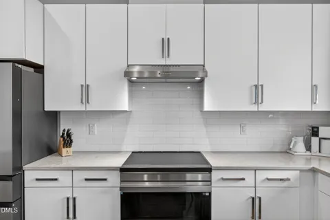 a kitchen with granite countertop a sink stainless steel appliances and cabinets
