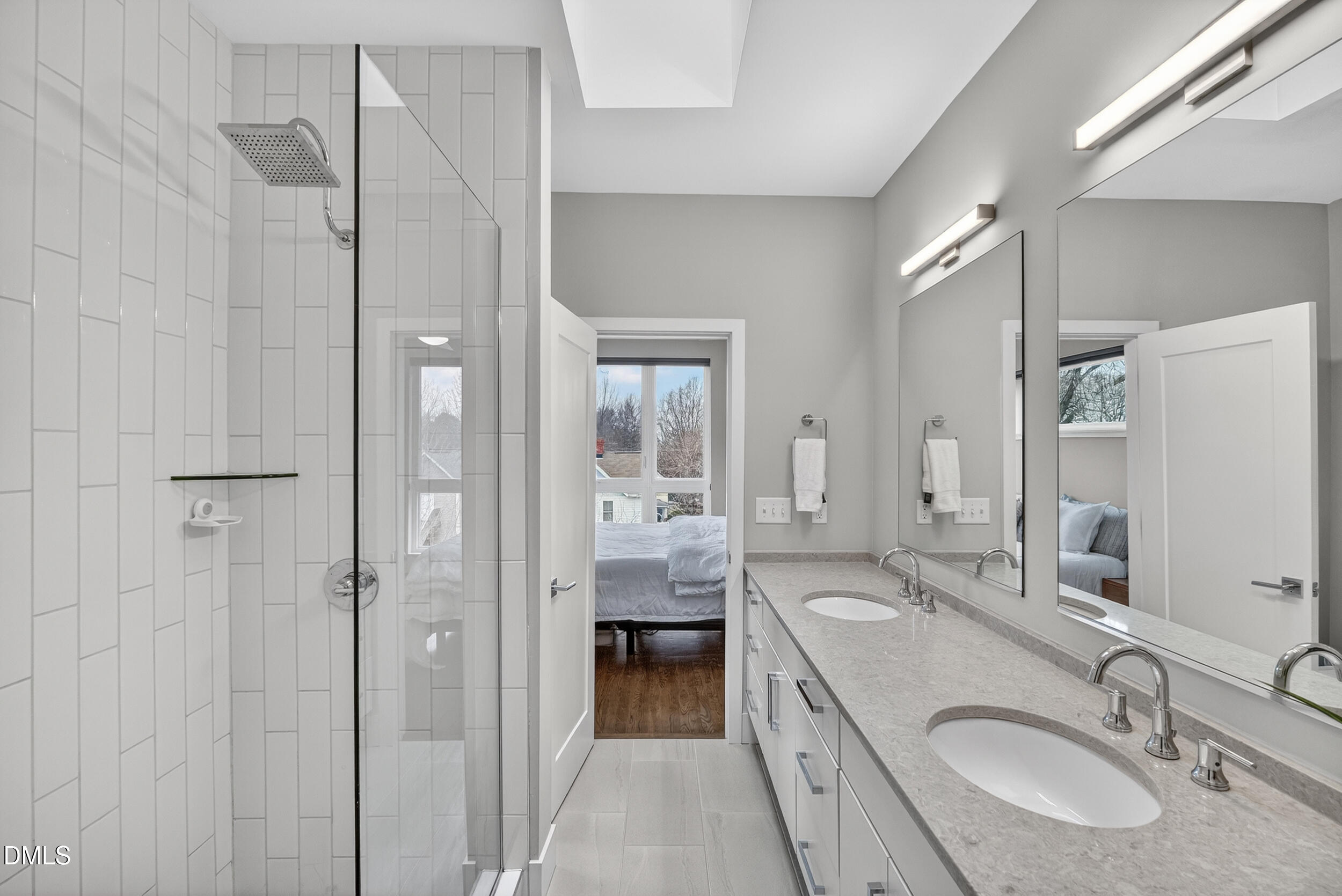 537 New Bern Avenue, Unit 101 Raleigh, NC 27601 - Photo 17 of 34 a en suite bathroom with a double vanity sink a mirror and shower
