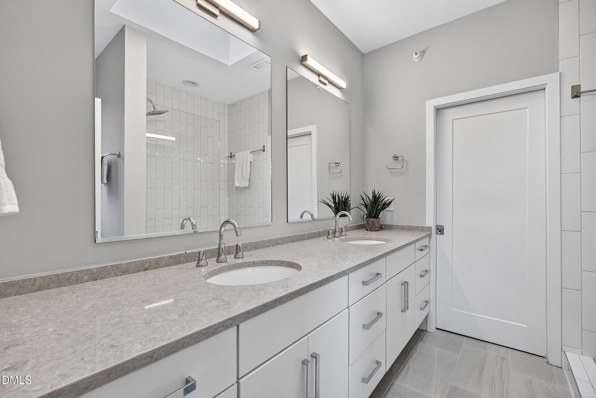 537 New Bern Avenue, Unit 101 Raleigh, NC 27601 - Photo 18 of 34 a bathroom with double sink and a mirror