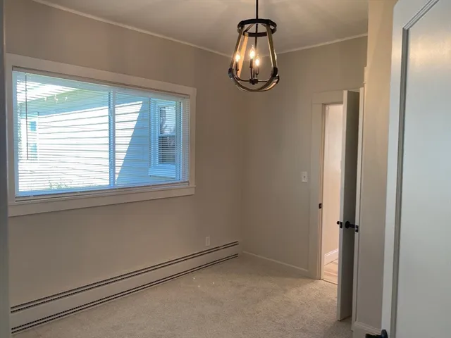 a view of empty room with windows and chandelier