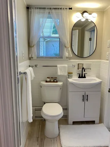 a bathroom with a toilet sink and mirror