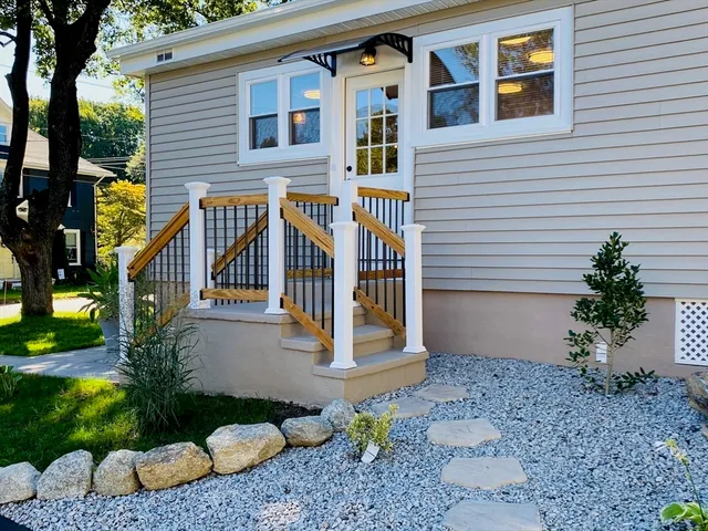 a view of a house with a yard and potted plants