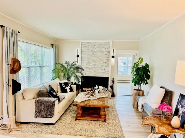 a living room with furniture flowerpot and wooden floor