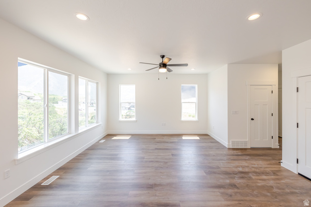 195 West Harmony Rdg Parkway, Unit 601 Mapleton, UT 84664 - Photo 9 of 23 Spacious room featuring multiple windows, recessed lighting, a ceiling fan, wood-finish flooring, and crisp white walls