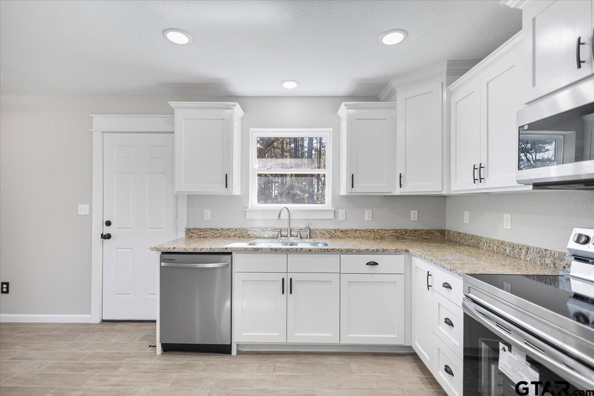 234 Sabinal Street Bullard, TX 75757 - Photo 11 of 30 a kitchen with granite countertop white cabinets and white appliances
