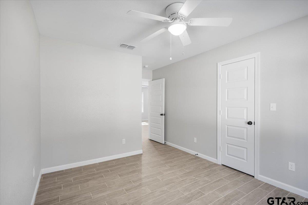 234 Sabinal Street Bullard, TX 75757 - Photo 14 of 30 an empty room with wooden floor and fan