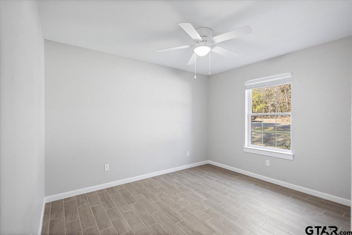 234 Sabinal Street Bullard, TX 75757 - Photo 15 of 30 an empty room with wooden floor fan and windows