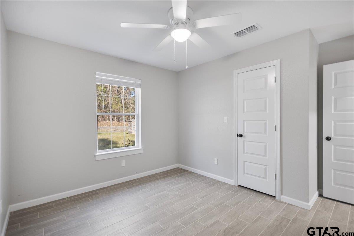 234 Sabinal Street Bullard, TX 75757 - Photo 16 of 30 an empty room with windows and chandelier fan