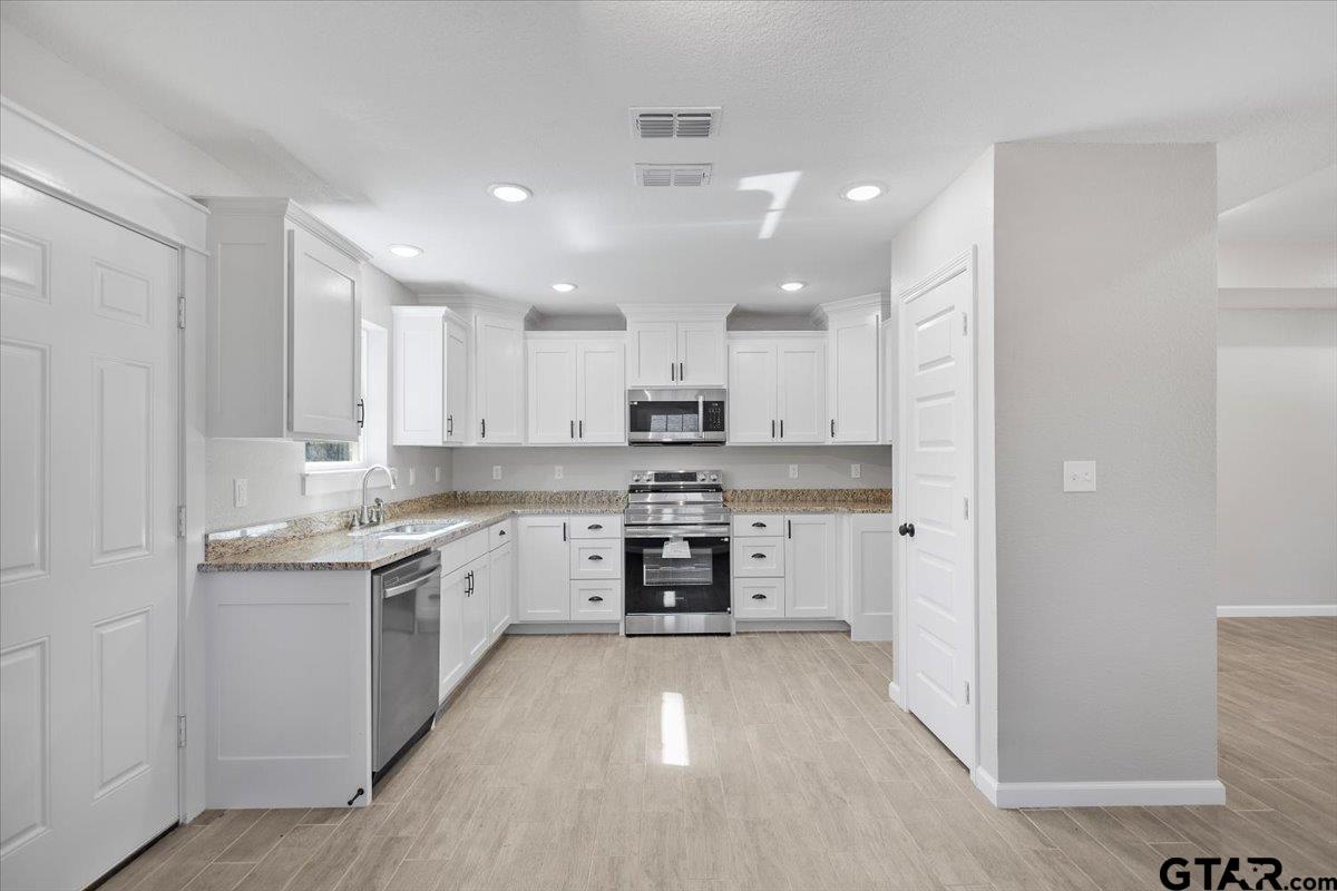 234 Sabinal Street Bullard, TX 75757 - Photo 9 of 30 a large kitchen with a white stove top oven and cabinets