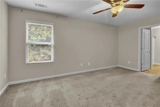 an empty room with a window and a fan