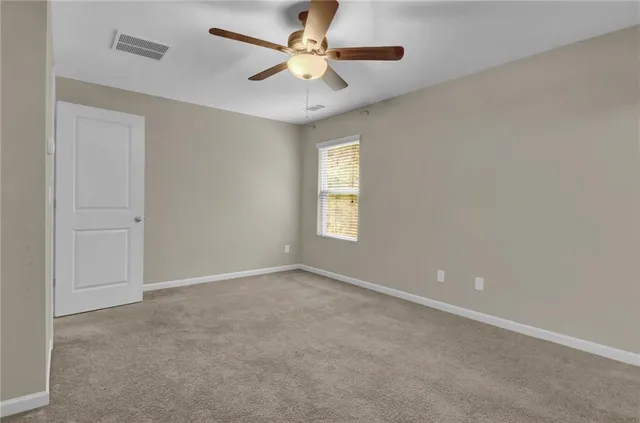an empty room with a window and a fan