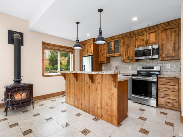 1317 South Pond Circle Mapleton, UT 84664 - Photo 24 of 63 Basement Kitchen featuring knotty pine cabinetry, stainless steel appliances, and a mosaic tile backsplash