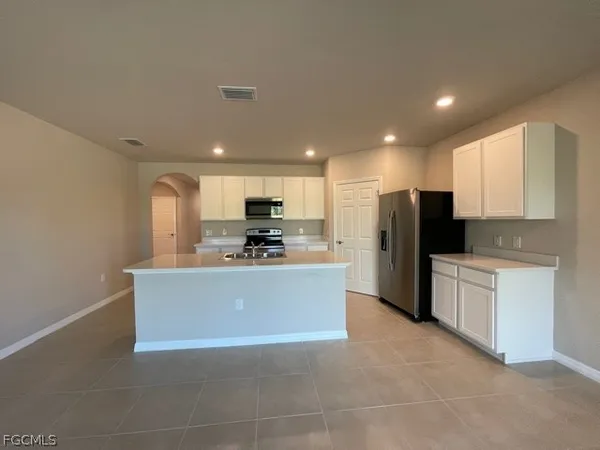 a kitchen with stainless steel appliances a refrigerator sink and microwave