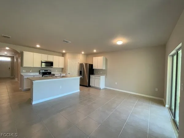a large open kitchen with kitchen island a sink a stove and a refrigerator
